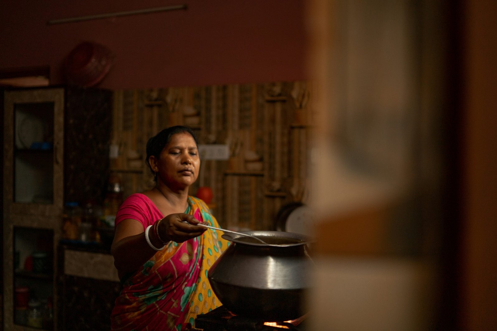 A pot of Indian food simmering on a home stove, seasoned by eye rather than measured spices