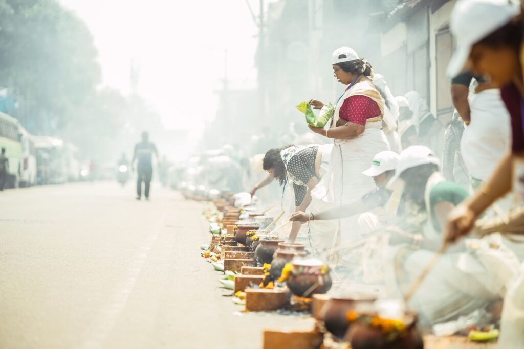 Women cooking pongala over rows of brick stoves at the Attukal Pongala festival in Kerala - Real Indian Food | A guide by Immerse India Tours